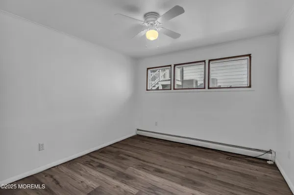 a view of a room with wooden floor and a ceiling fan