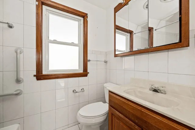 a bathroom with a sink a toilet and a window