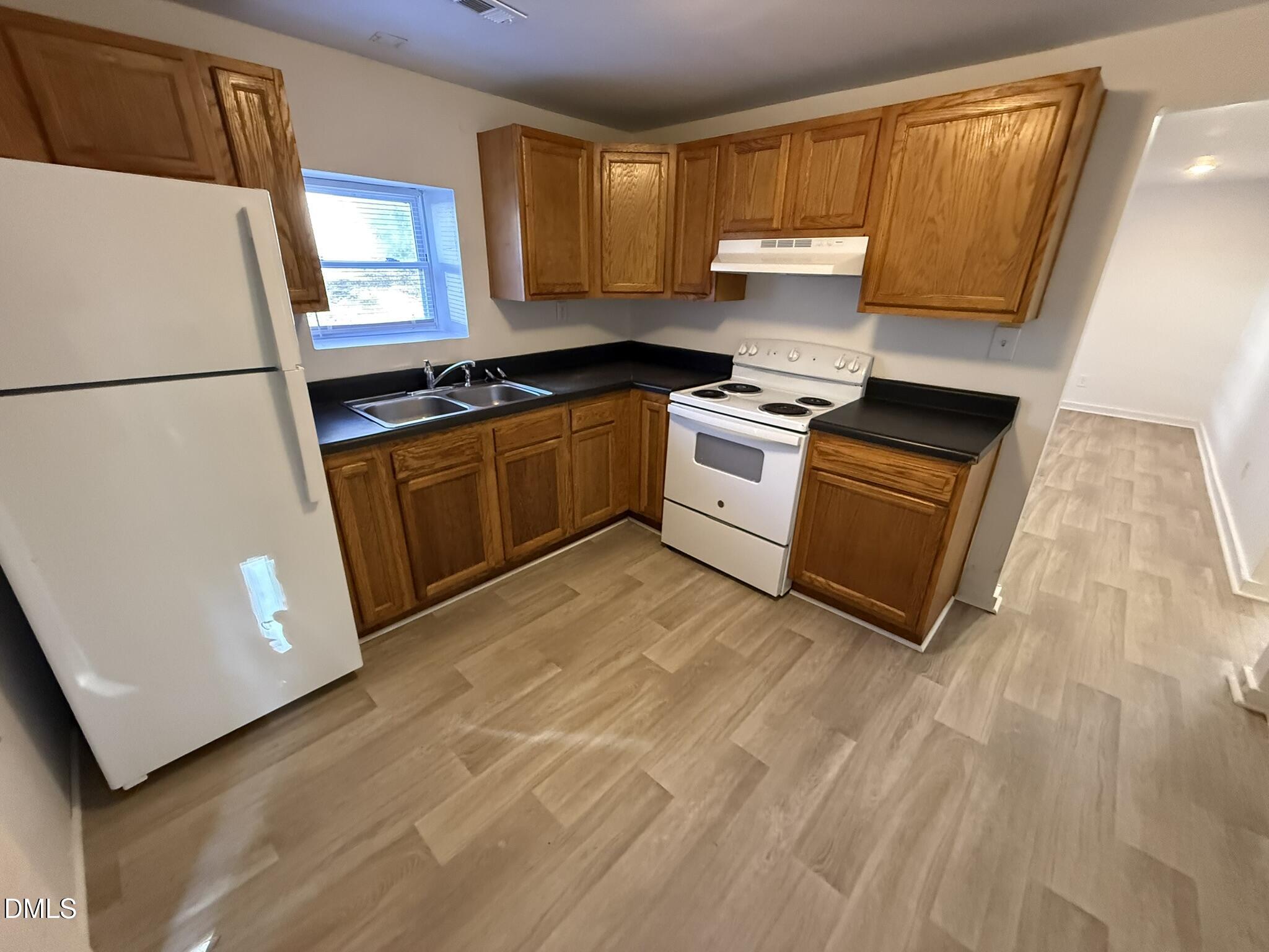 1113 Gurley Street, Unit B Durham, NC 27701 - Photo 3 of 10 a kitchen with granite countertop a refrigerator sink and cabinets