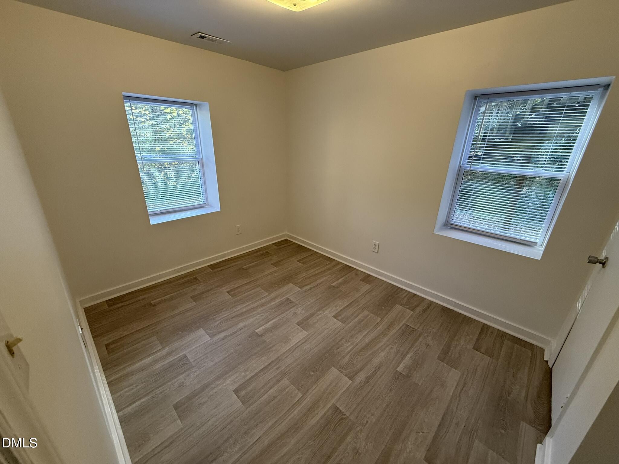 1113 Gurley Street, Unit B Durham, NC 27701 - Photo 7 of 10 a view of an empty room with a window and wooden floor