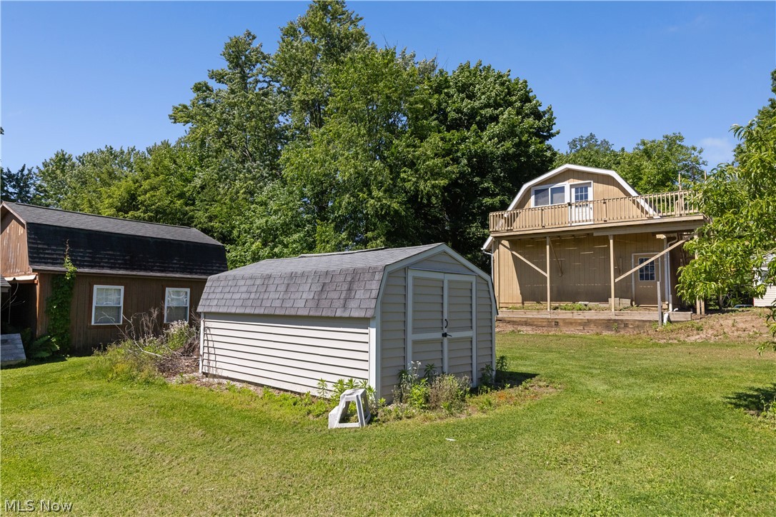 409 Edith Avenue Akron, OH 44312 - Photo 34 of 45 Expansive backyard featuring a detached storage shed, a barn structure, and a secondary building with an upper-level balcony