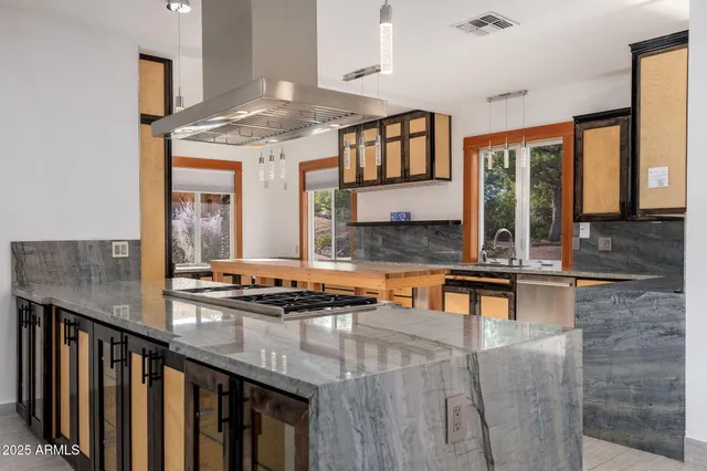 a kitchen with stainless steel appliances granite countertop a stove and a wooden floors
