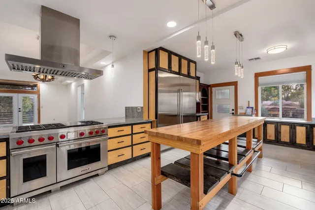 a kitchen with kitchen island a stove and a sink