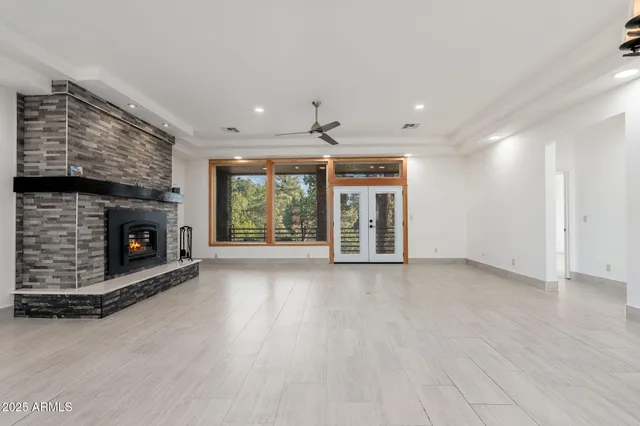 a view of an empty room with a fireplace and window