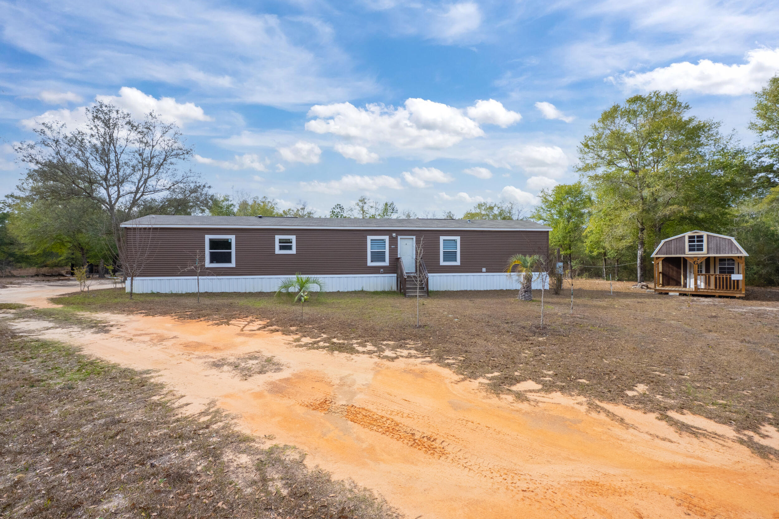 4528 Bryant Bridge Cutoff Road Holt, FL 32564 - Photo 1 of 63 a front view of a house with a yard