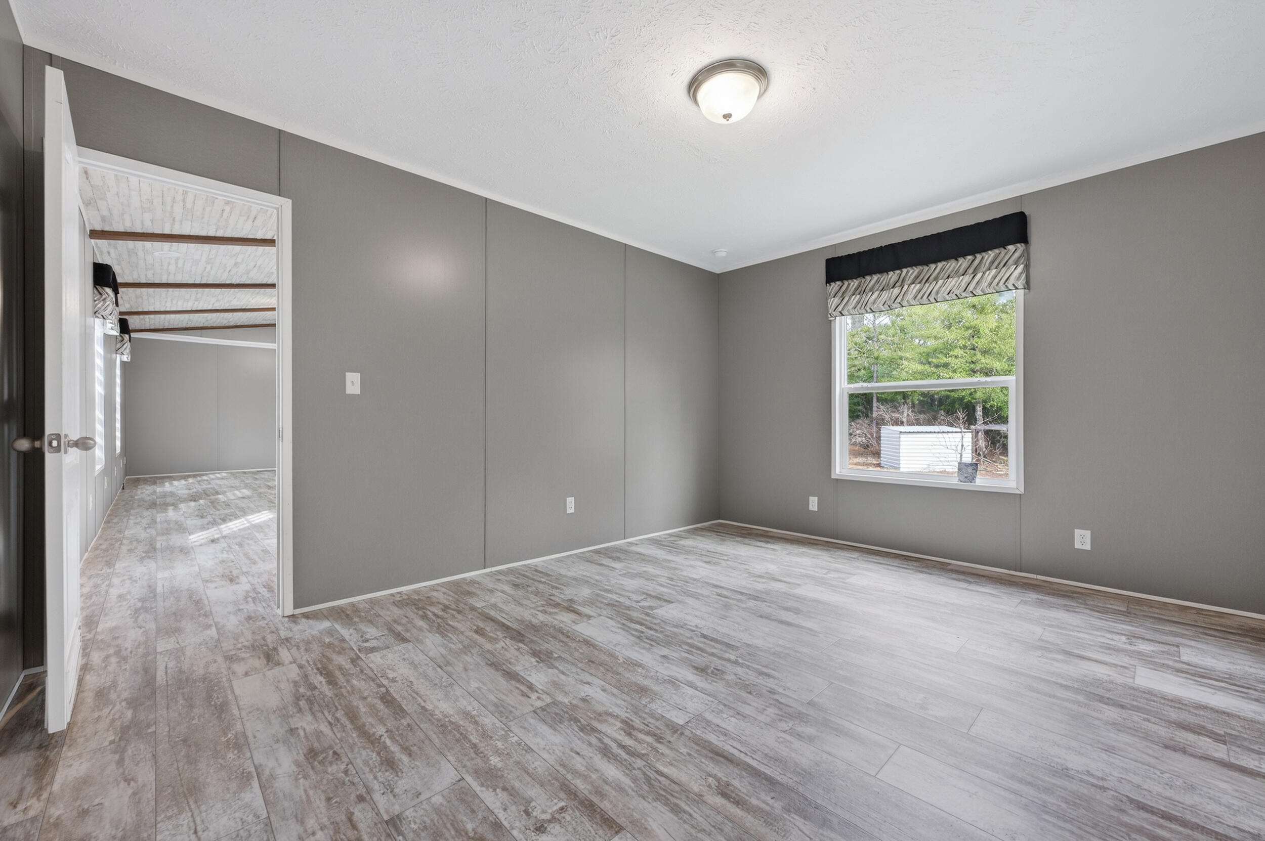 4528 Bryant Bridge Cutoff Road Holt, FL 32564 - Photo 20 of 63 a view of an empty room with wooden floor and a window