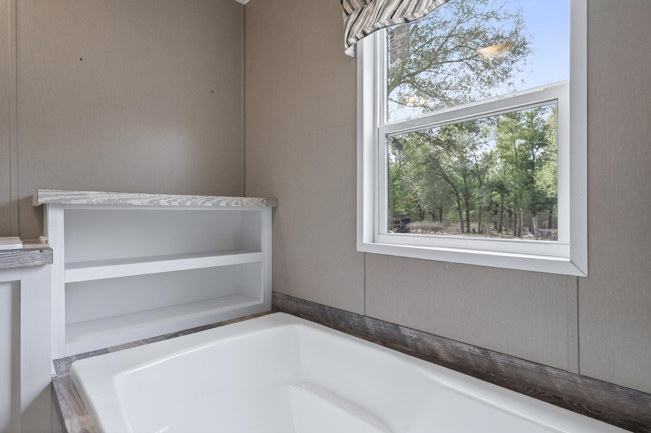 4528 Bryant Bridge Cutoff Road Holt, FL 32564 - Photo 29 of 63 a white bath tub sitting next to a window
