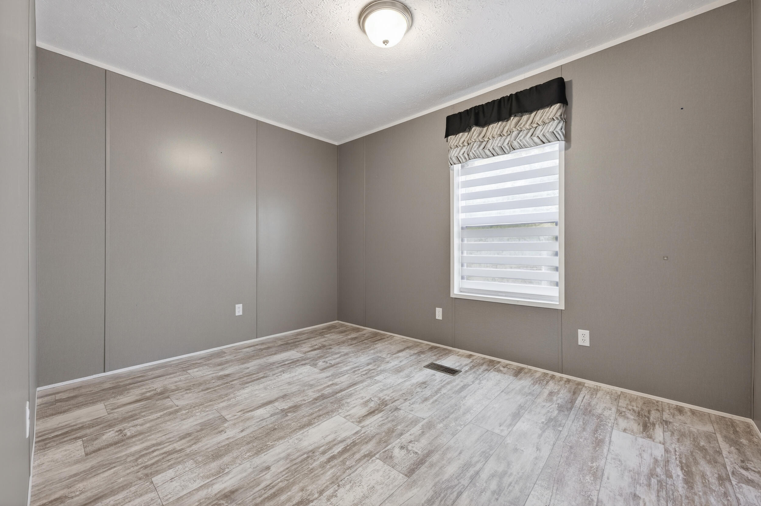 4528 Bryant Bridge Cutoff Road Holt, FL 32564 - Photo 30 of 63 a view of an empty room with wooden floor and a window