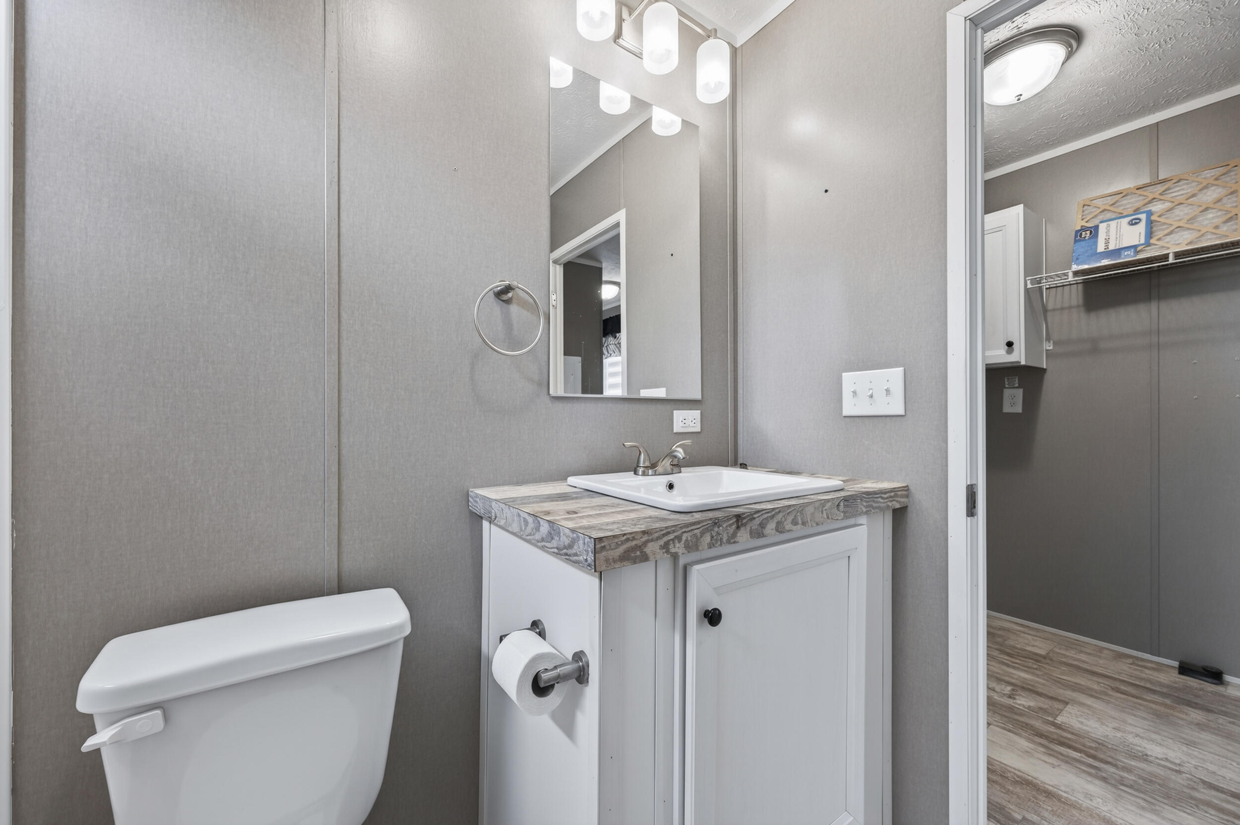 4528 Bryant Bridge Cutoff Road Holt, FL 32564 - Photo 37 of 63 a bathroom with a granite countertop sink a toilet and mirror