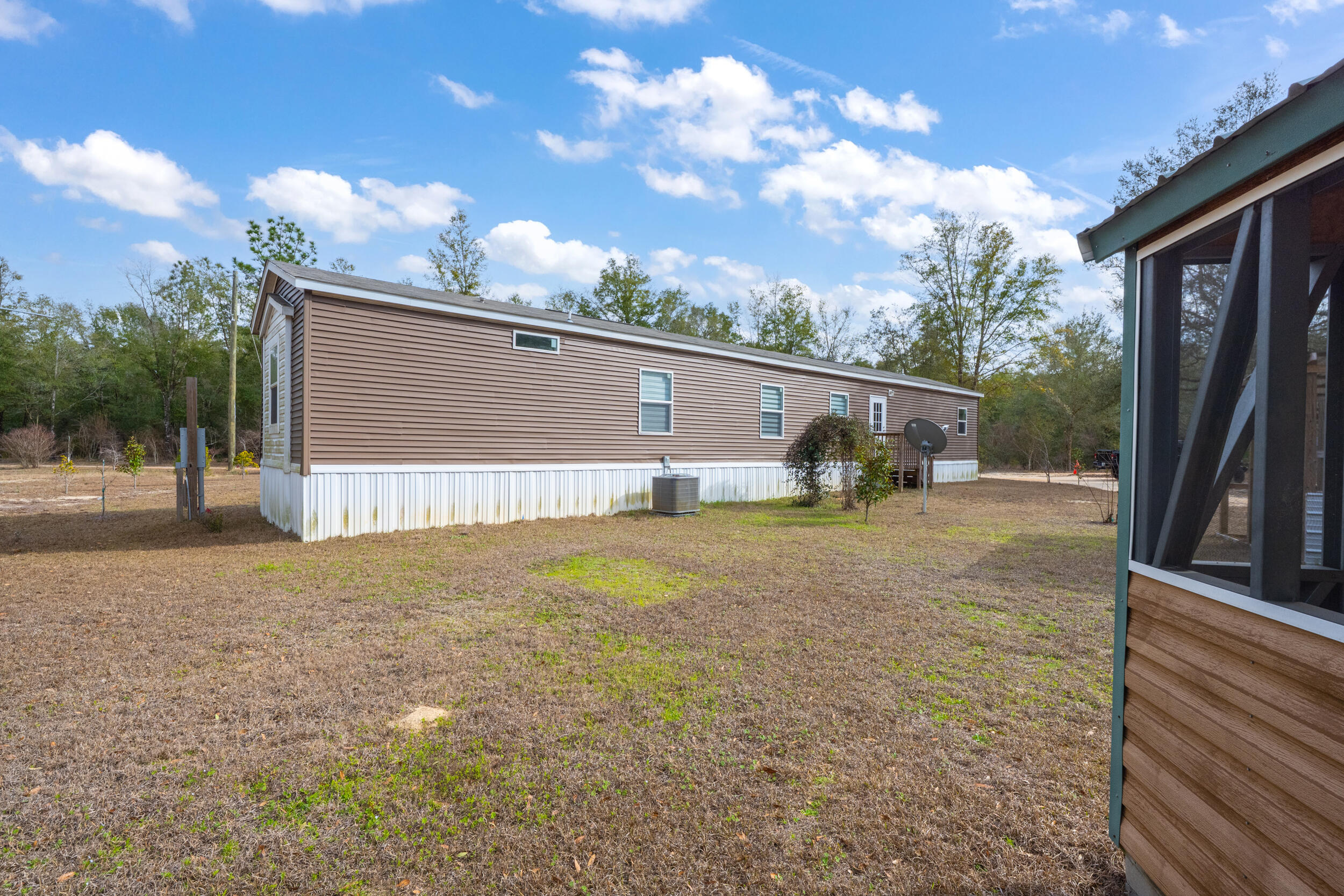 4528 Bryant Bridge Cutoff Road Holt, FL 32564 - Photo 49 of 63 a backyard of a house with table and chairs