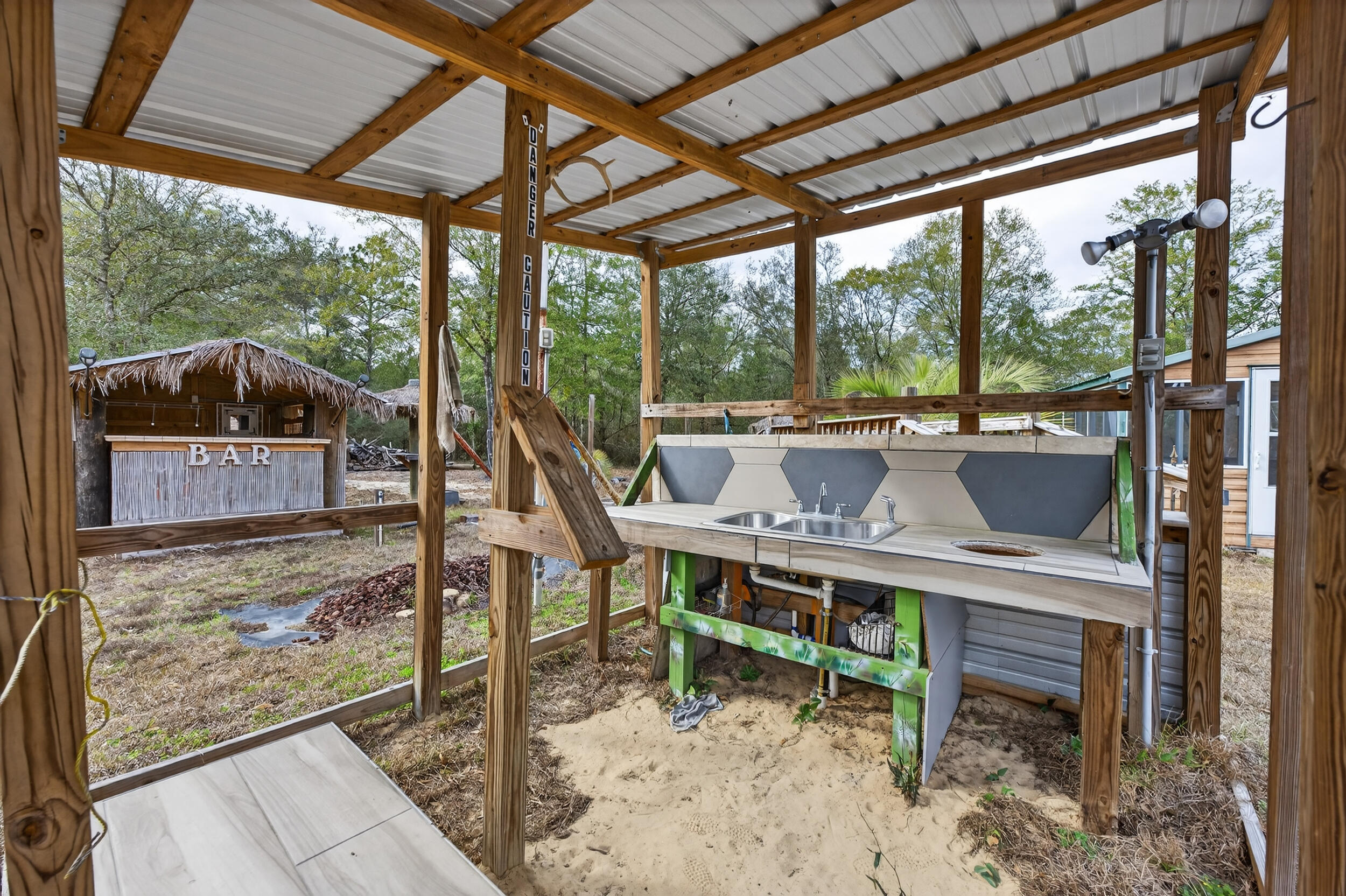 4528 Bryant Bridge Cutoff Road Holt, FL 32564 - Photo 52 of 63 a view of a porch with chairs and backyard