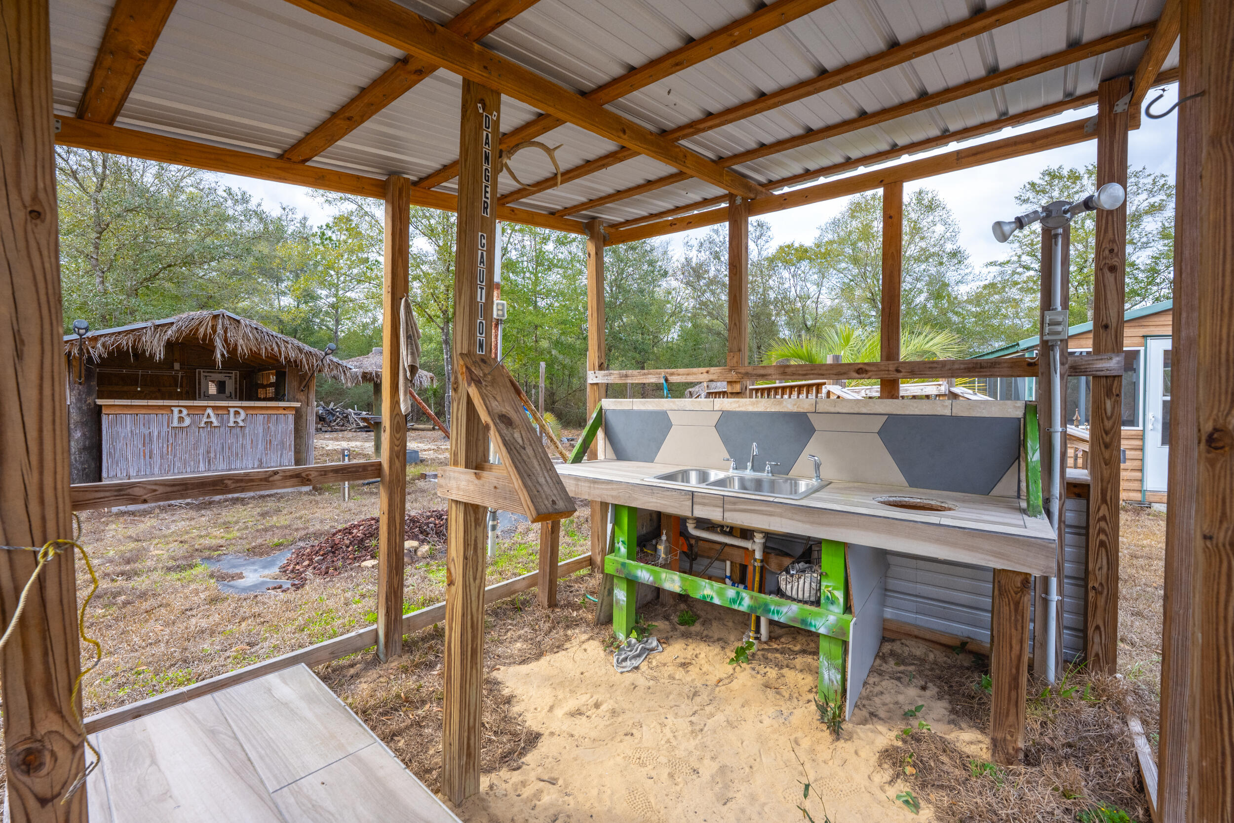 4528 Bryant Bridge Cutoff Road Holt, FL 32564 - Photo 53 of 63 a view of a porch with chairs and backyard