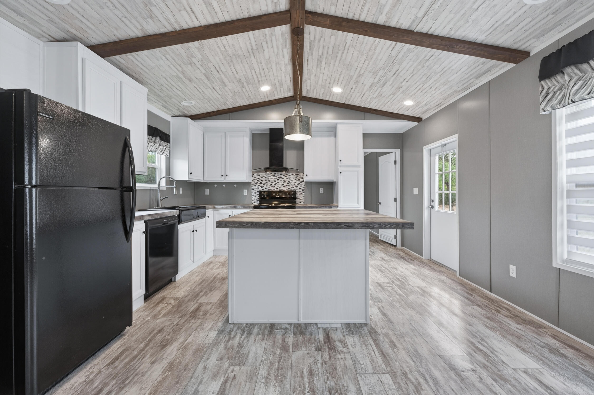 4528 Bryant Bridge Cutoff Road Holt, FL 32564 - Photo 7 of 63 a kitchen with a refrigerator a sink and dishwasher with wooden floor