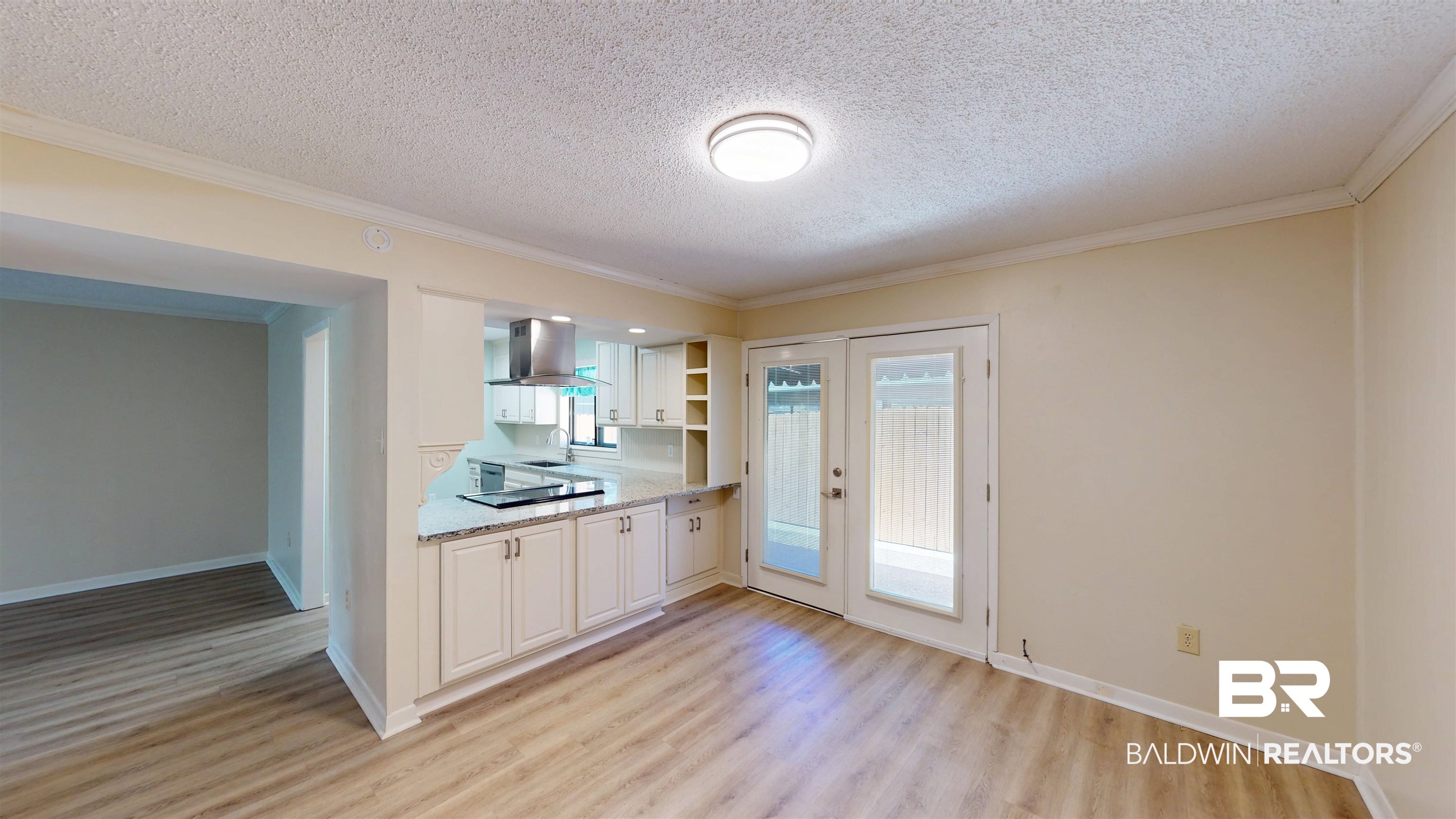 2901 Grant Street, Unit 902 Mobile, AL 36606 - Photo 11 of 35 Kitchen featuring crown molding, light wood-style flooring, a textured ceiling, ventilation hood, and open shelves