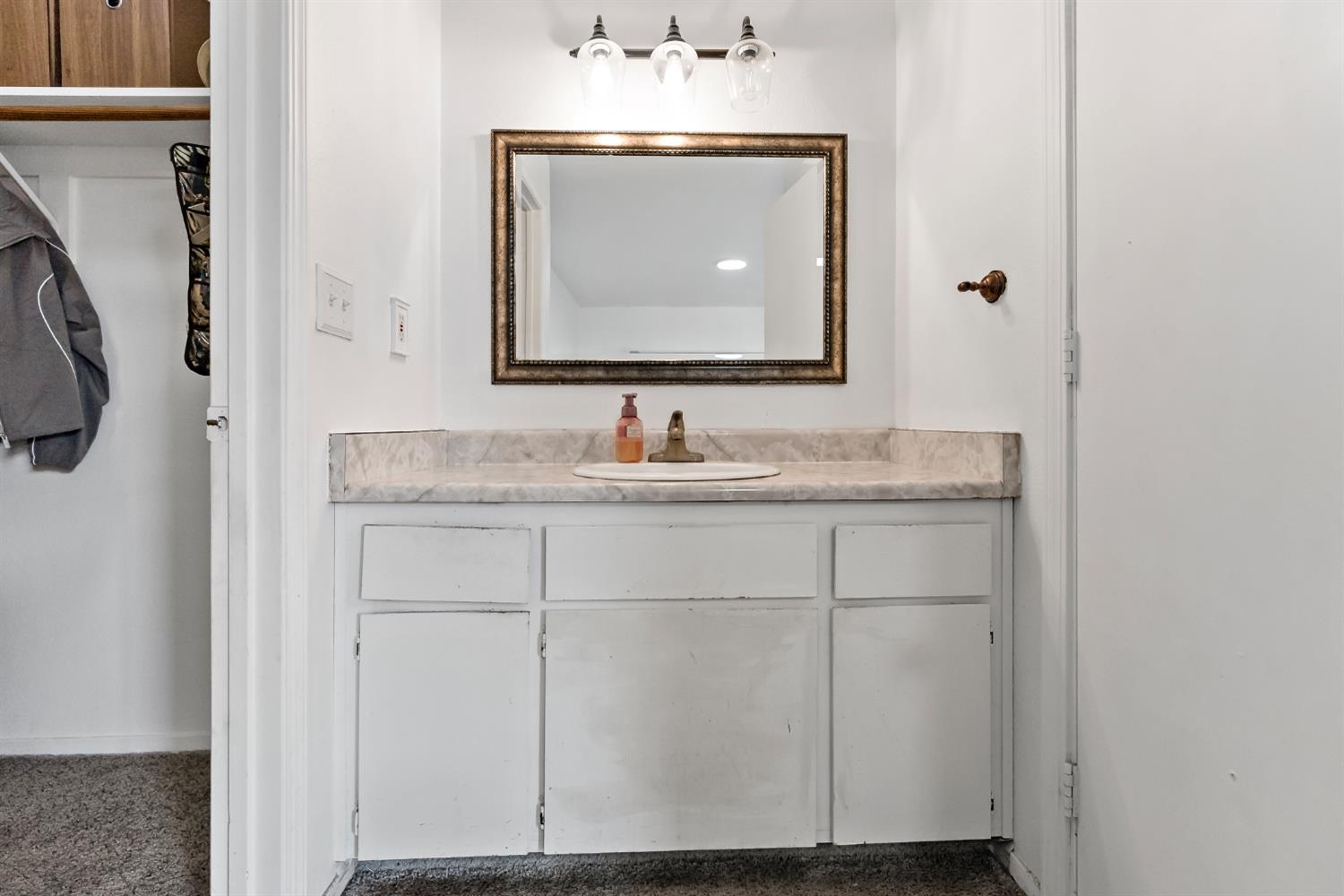 398 Helena Way Madera, CA 93637 - Photo 18 of 23 a bathroom with a sink and a mirror