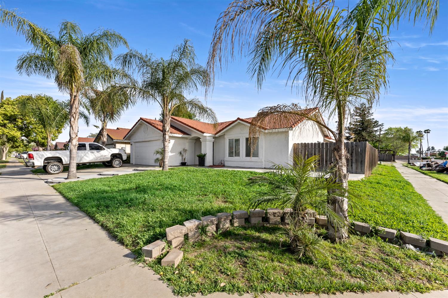 398 Helena Way Madera, CA 93637 - Photo 2 of 23 a view of a white house with a yard and potted plants