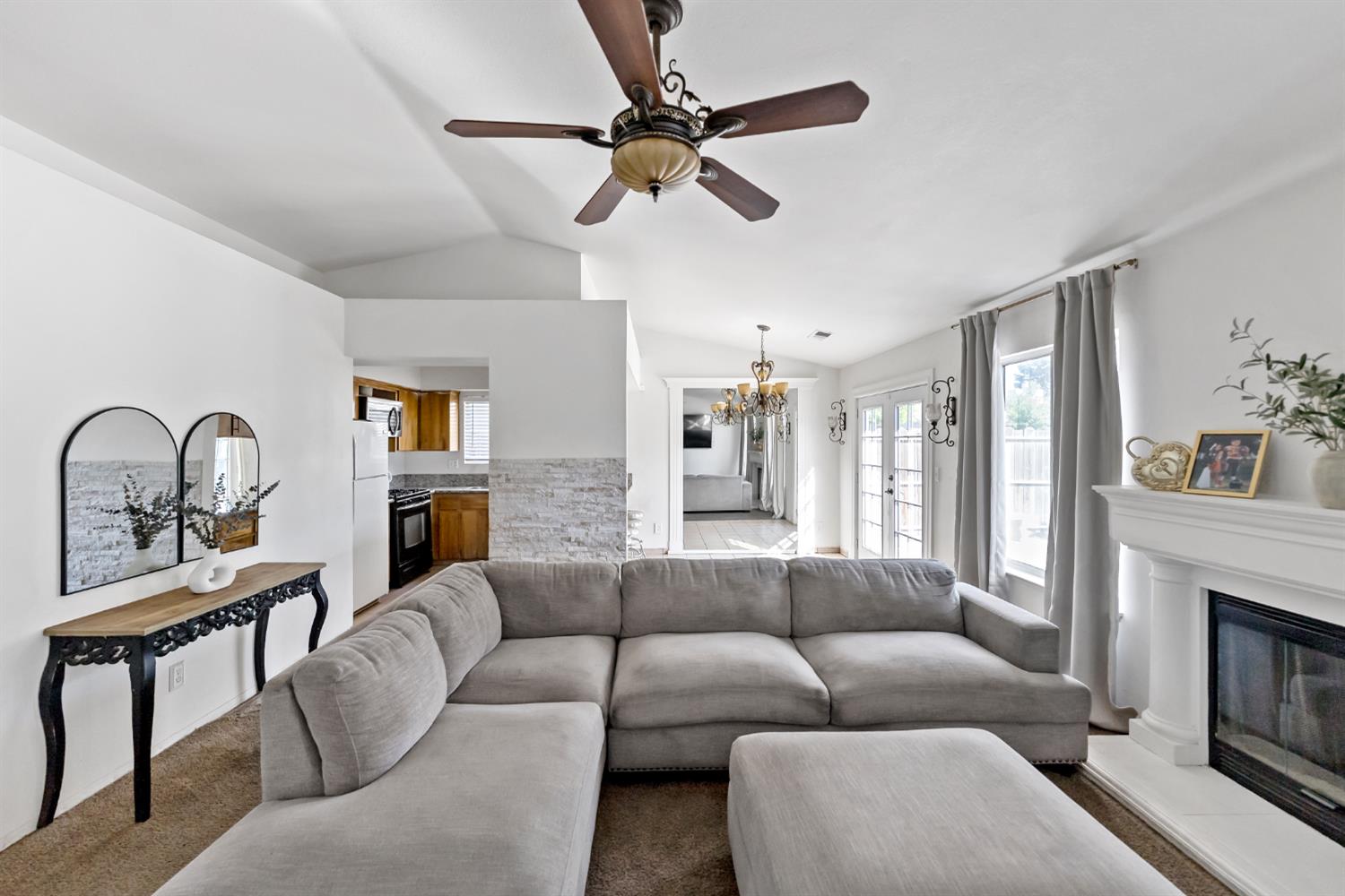 398 Helena Way Madera, CA 93637 - Photo 4 of 23 a living room with furniture a fireplace and a chandelier