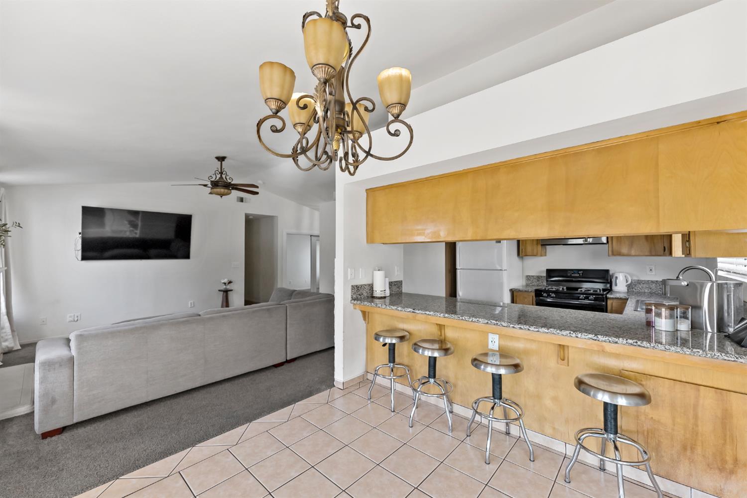 398 Helena Way Madera, CA 93637 - Photo 7 of 23 a kitchen with stainless steel appliances granite countertop a sink and white cabinets