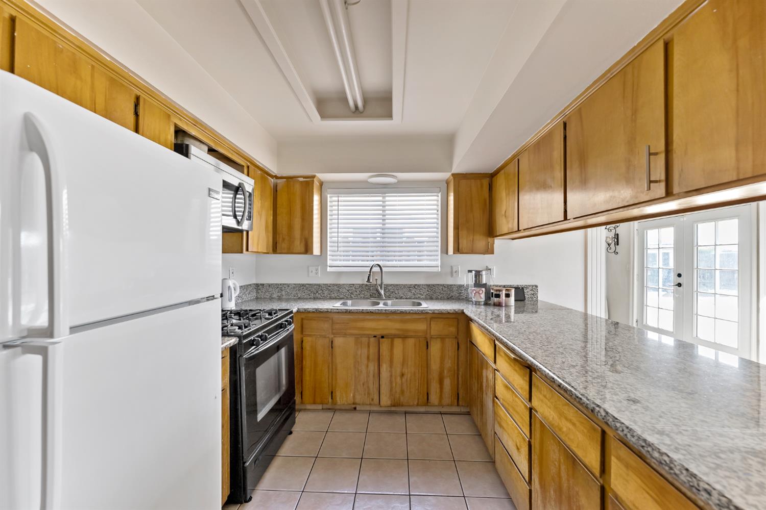 398 Helena Way Madera, CA 93637 - Photo 8 of 23 a kitchen with a sink a stove top oven and cabinetry
