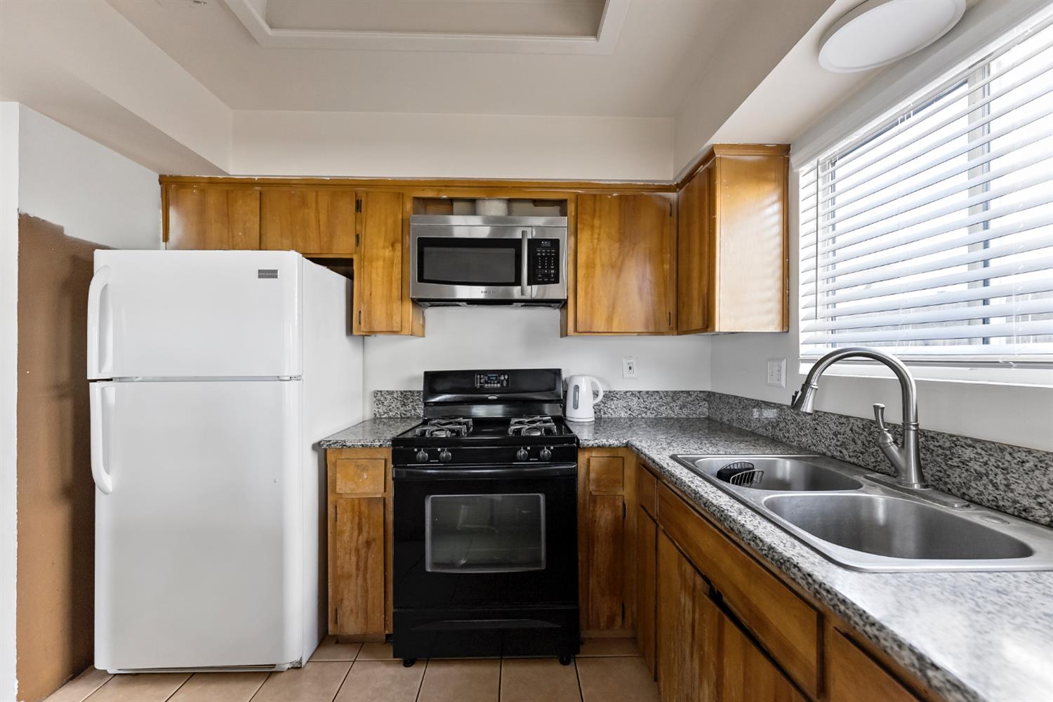 398 Helena Way Madera, CA 93637 - Photo 9 of 23 a kitchen with a refrigerator stove and sink