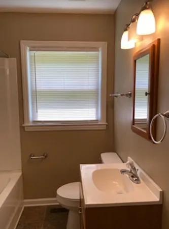 a bathroom with a sink mirror and toilet