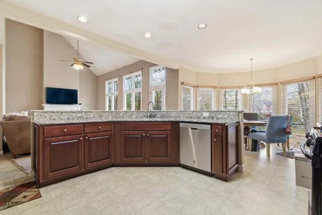 a kitchen with stainless steel appliances granite countertop a refrigerator and wooden cabinets