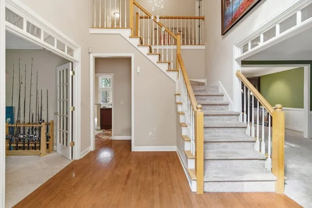 a view of staircase with lots of frames on wall and a dining table