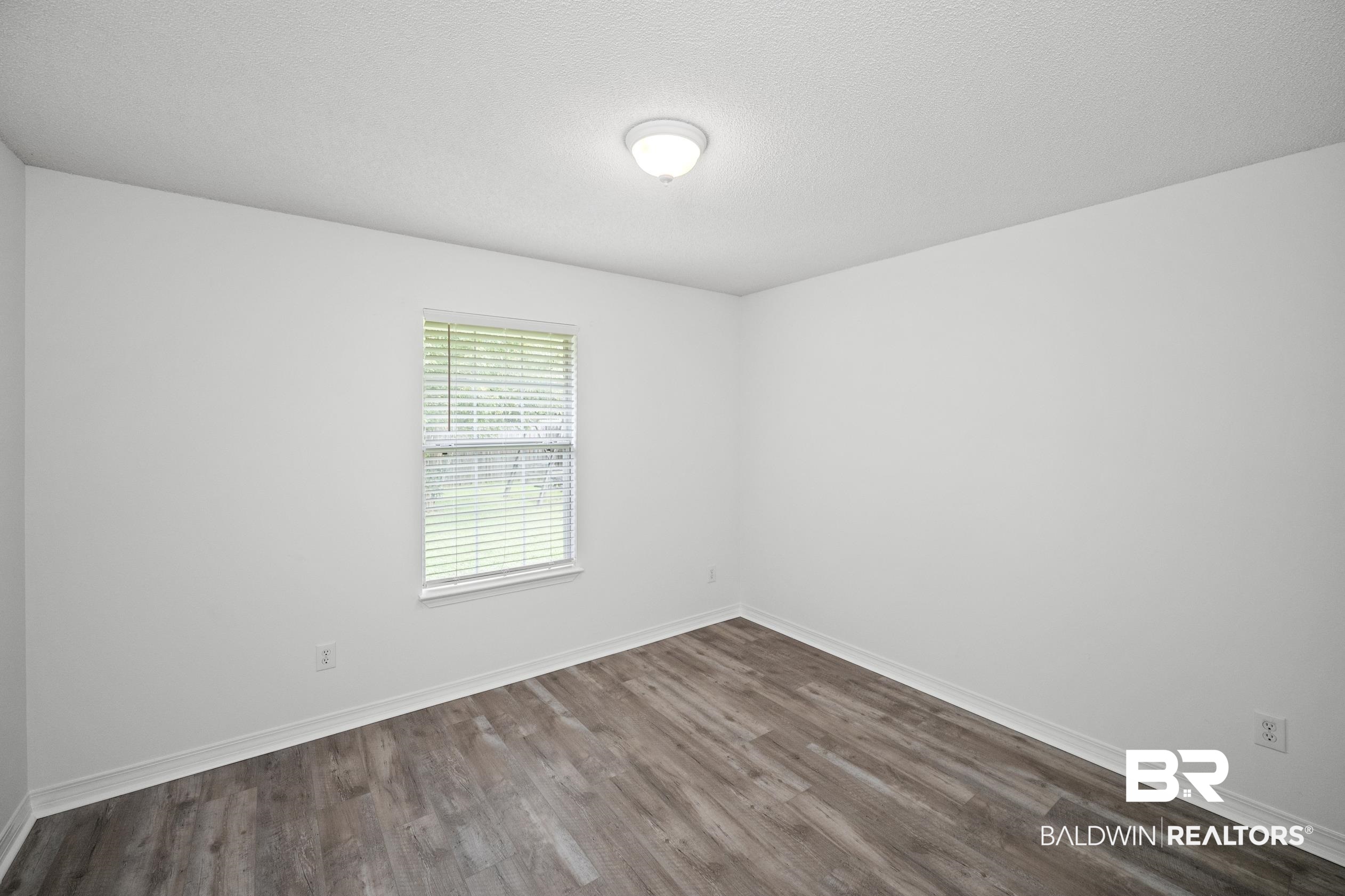 306 Monteith Oaks Drive Foley, AL 36535 - Photo 21 of 38 Unfurnished room featuring dark wood-type flooring and a textured ceiling