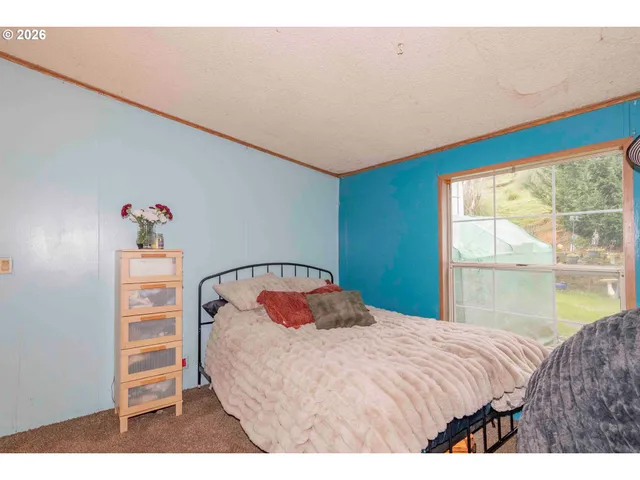 a bedroom with a bed and a large window