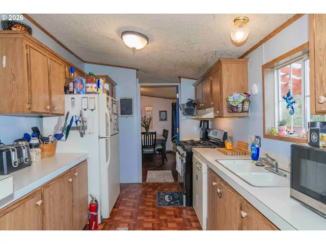a kitchen view of a sink stove and a refrigerator