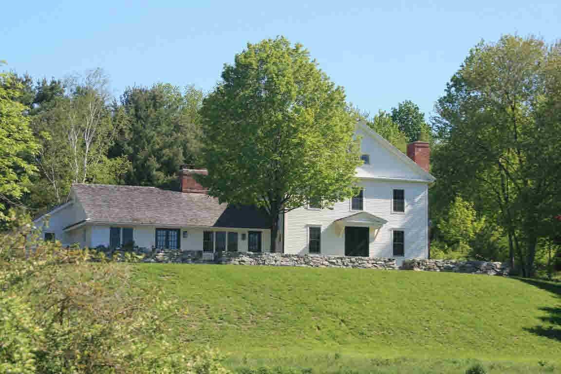 100 Reservoir Road Lakeville, CT 06039 - Photo 1 of 1 a front view of a house with a garden