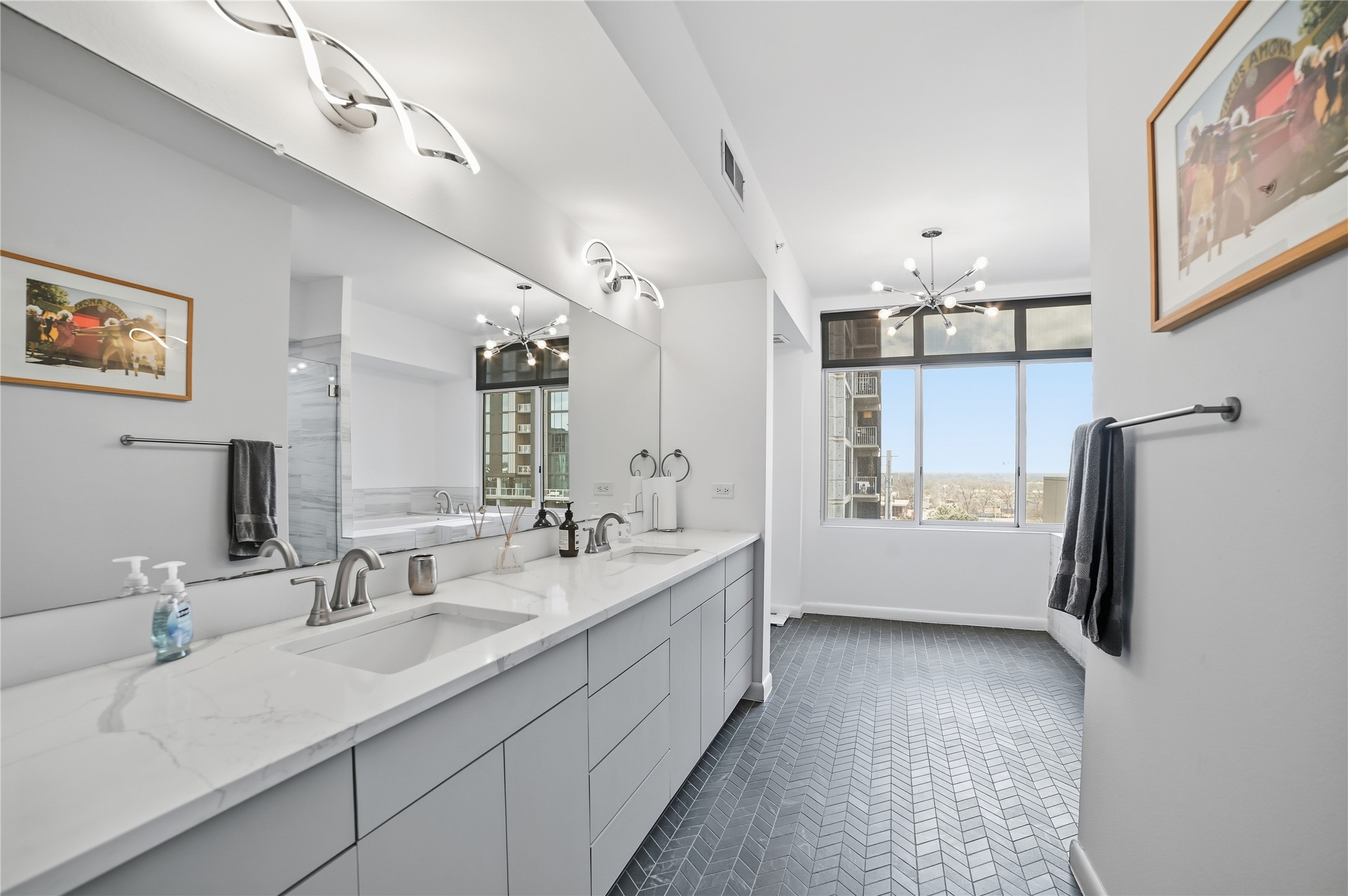 54 Rainey Street, Unit 1018 Austin, TX 78701 - Photo 17 of 32 a bathroom with a double vanity sink a mirror a bathtub and shower