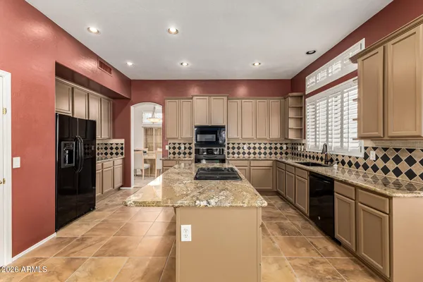 a kitchen with stainless steel appliances granite countertop a sink stove and cabinets
