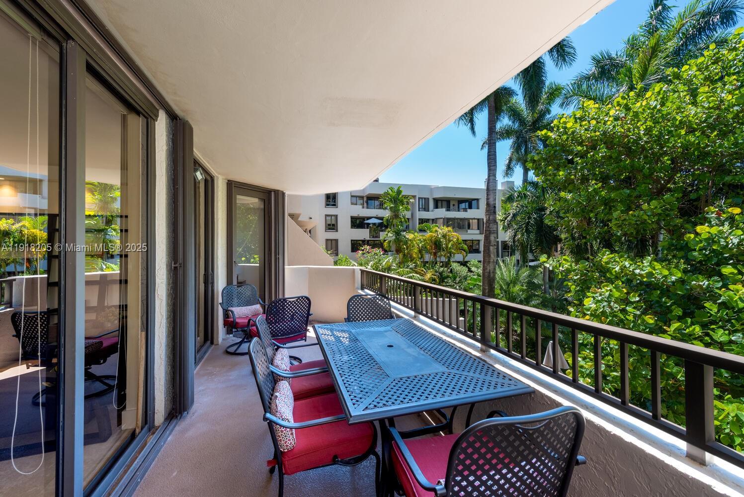 141 Crandon Boulevard, Unit 235 Key Biscayne, FL 33149 - Photo 1 of 25 a balcony with wooden floor table and chairs