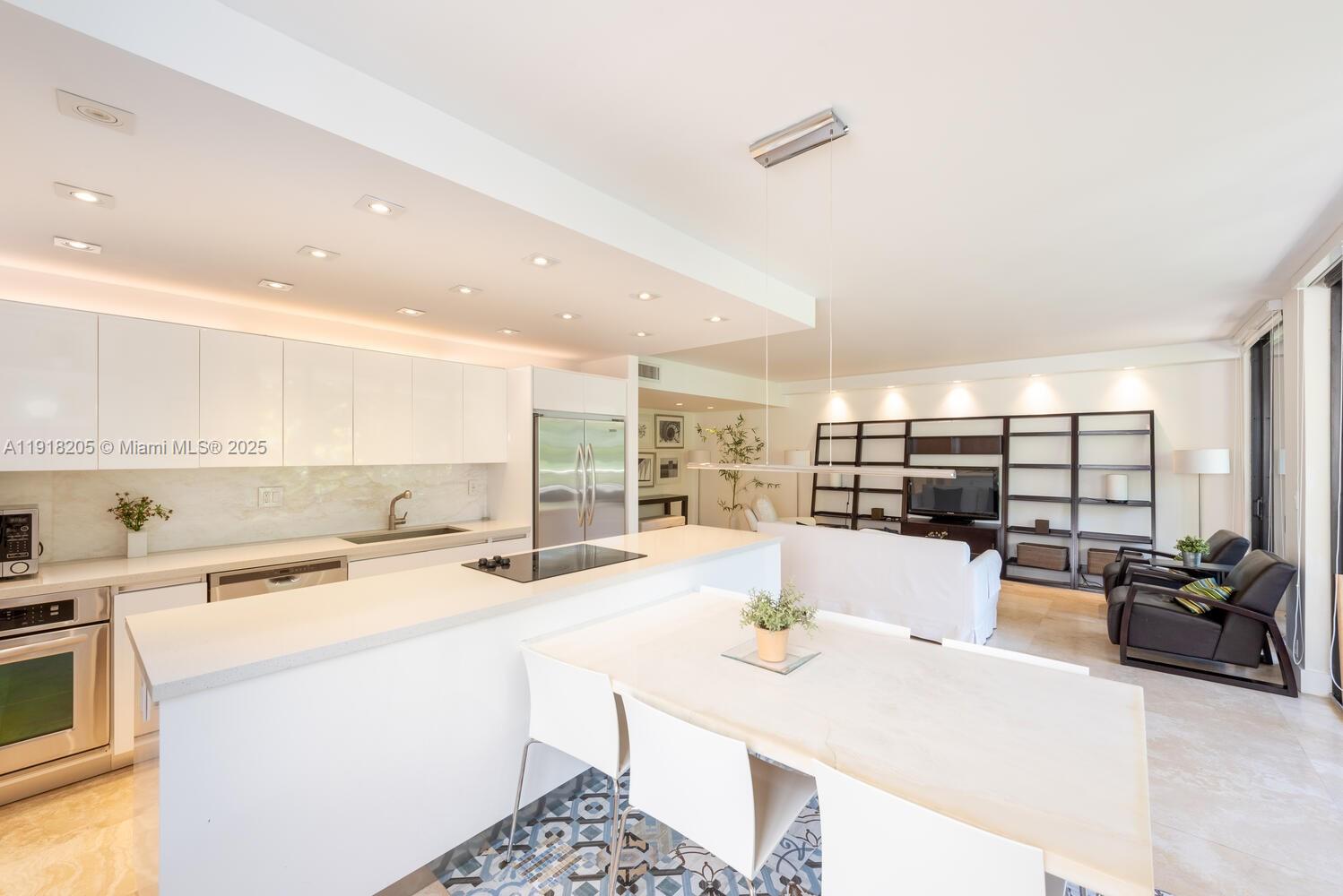 141 Crandon Boulevard, Unit 235 Key Biscayne, FL 33149 - Photo 11 of 25 a kitchen with stainless steel appliances kitchen island granite countertop a sink and cabinets