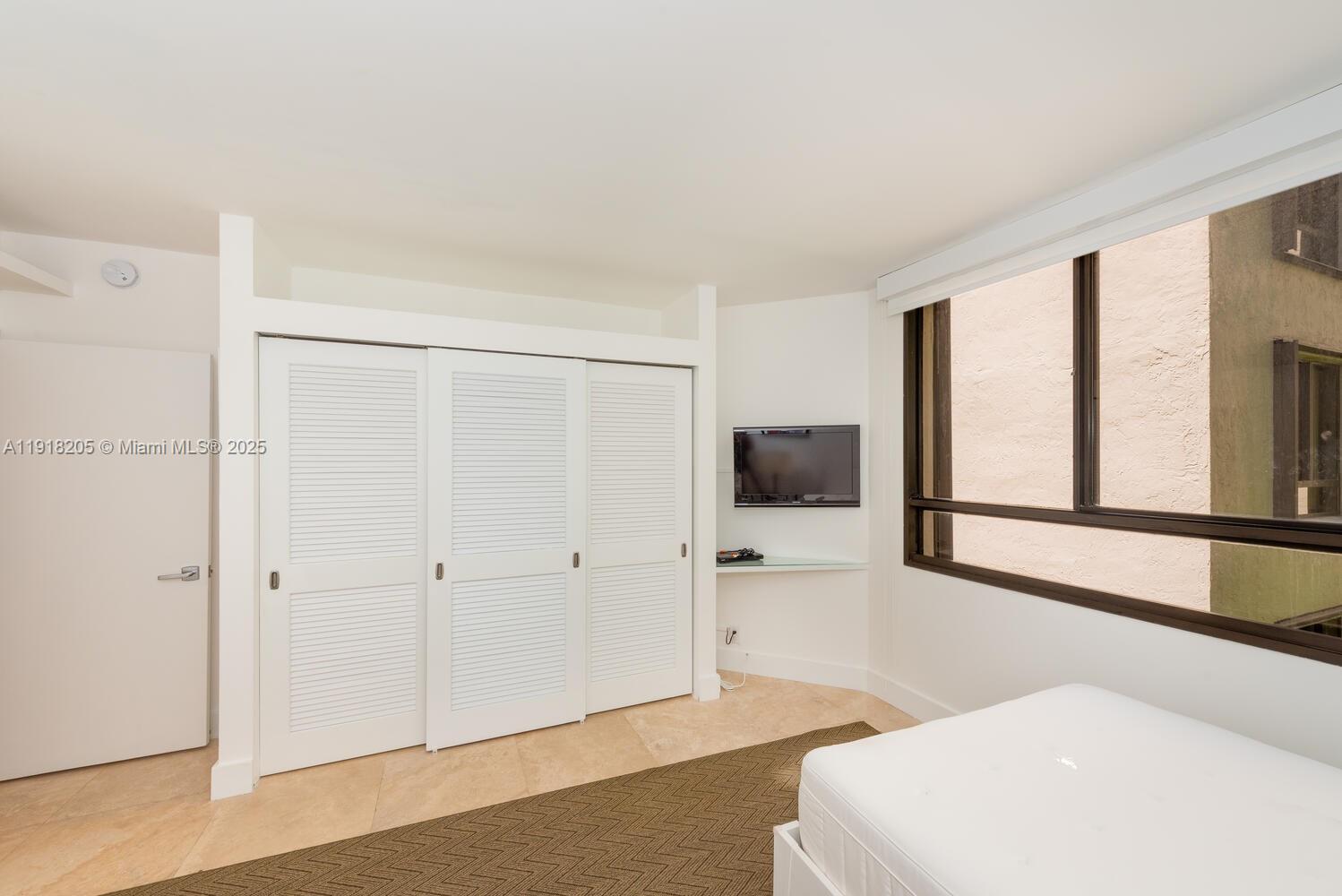 141 Crandon Boulevard, Unit 235 Key Biscayne, FL 33149 - Photo 18 of 25 a living room with furniture and a flat screen tv