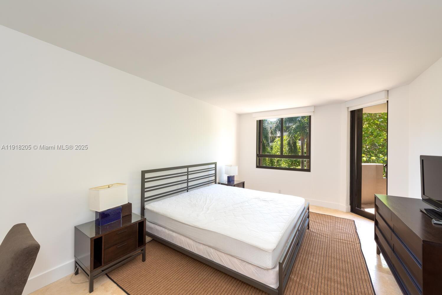 141 Crandon Boulevard, Unit 235 Key Biscayne, FL 33149 - Photo 19 of 25 a bedroom with a bed and a large window