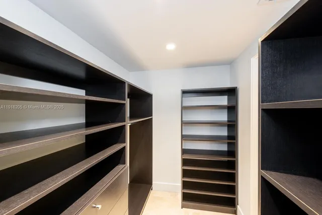 a view of walk in closet with empty racks