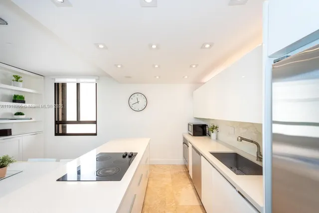a large white kitchen with a large window