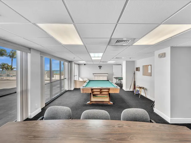 a view of a hall with a dining table chairs and iron gate