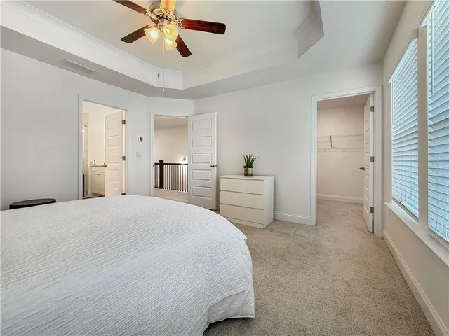 a spacious bedroom with a bed and a chandelier