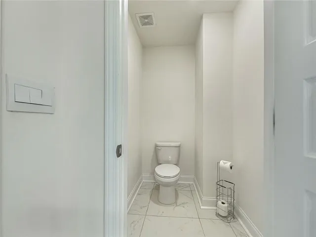 a white toilet sitting next to a white cabinet