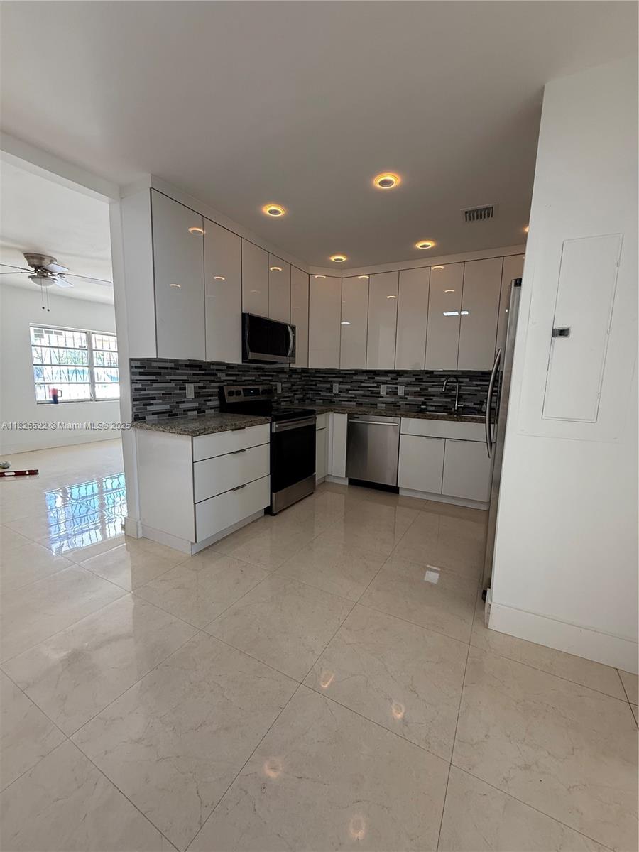 Flagami Miami, FL 33144 - Photo 1 of 20 a large kitchen with granite countertop a stove top oven a sink a counter space and cabinets