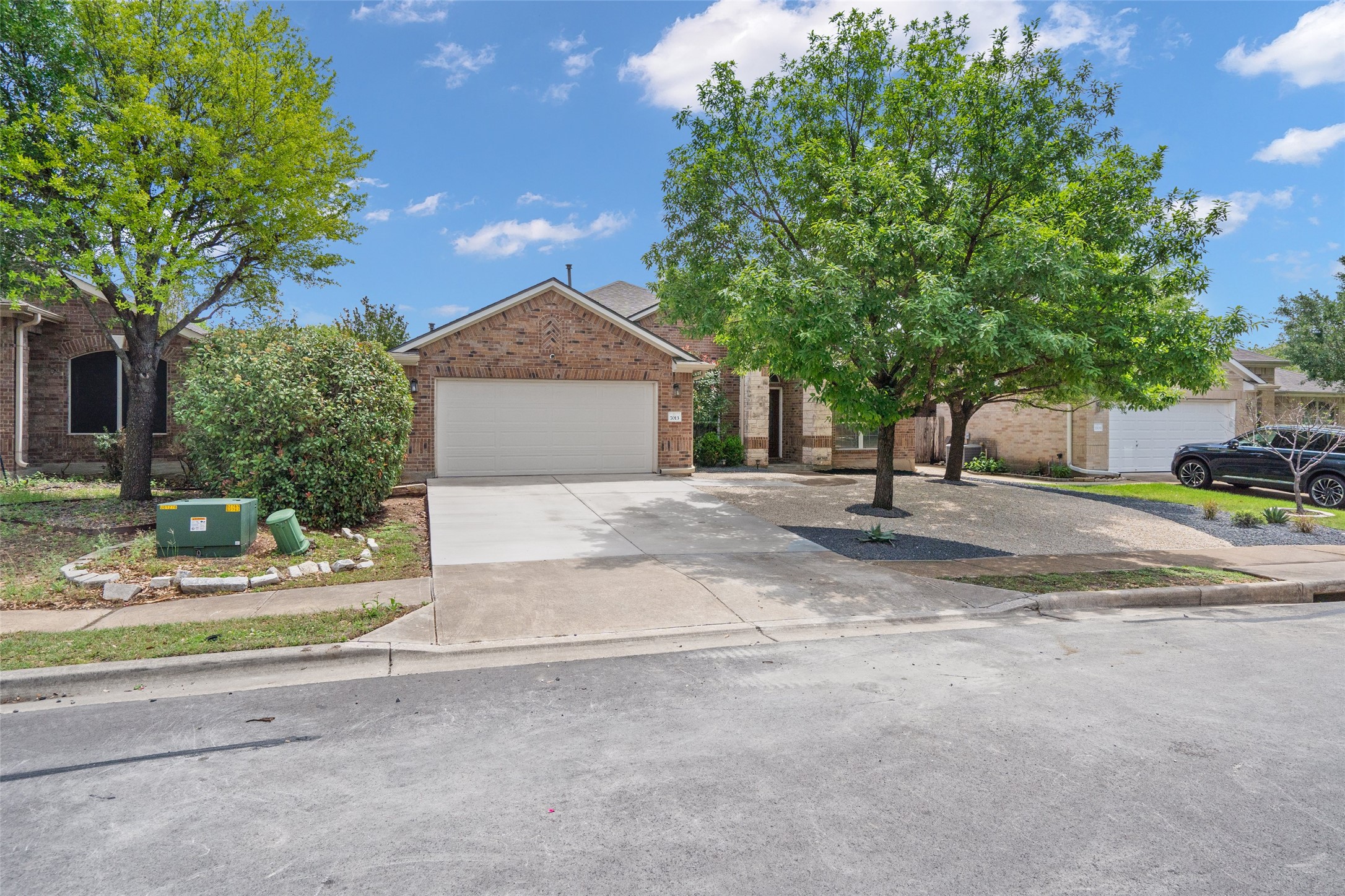 7013 Cromarty Lane Austin, TX 78754 - Photo 2 of 37 The property features a brick exterior, an attached garage, and a concrete driveway