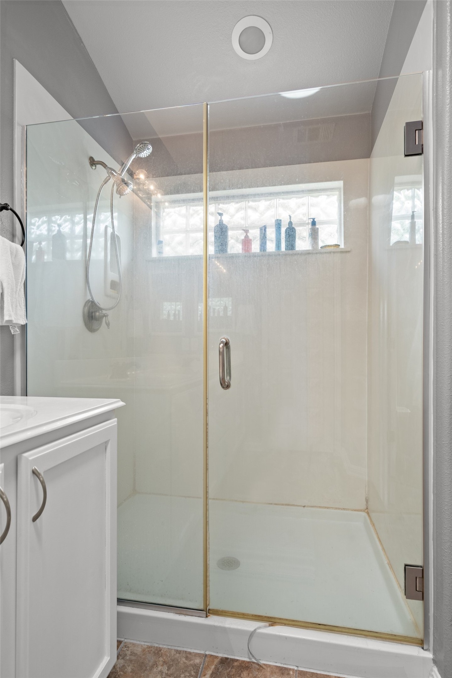 7013 Cromarty Lane Austin, TX 78754 - Photo 23 of 37 The bathroom features a glass-enclosed shower with a handheld shower head and an overhead light
