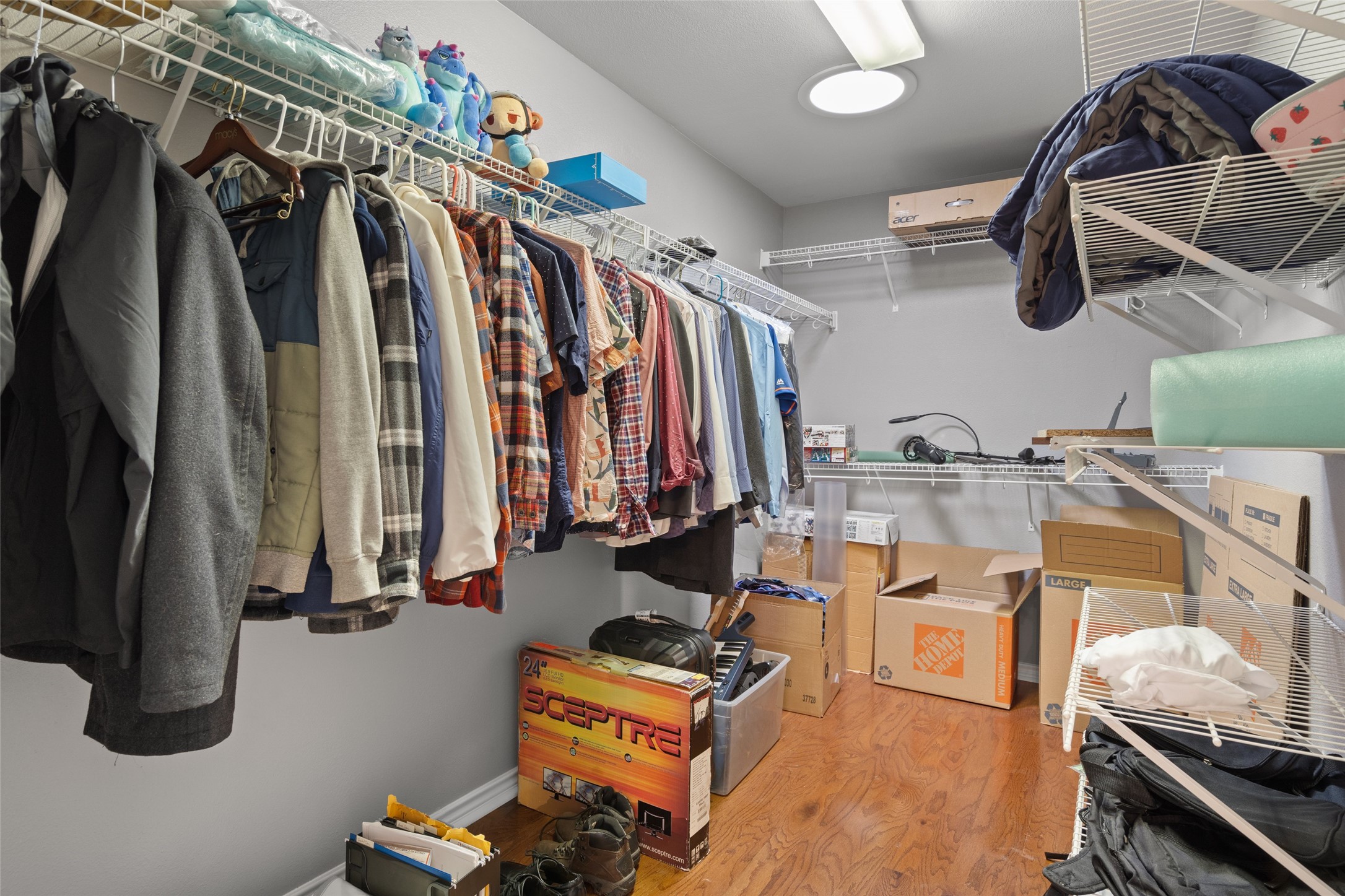 7013 Cromarty Lane Austin, TX 78754 - Photo 24 of 37 The property features a walk-in closet with extensive wire shelving and hanging rods, complemented by hardwood flooring and a ceiling light fixture