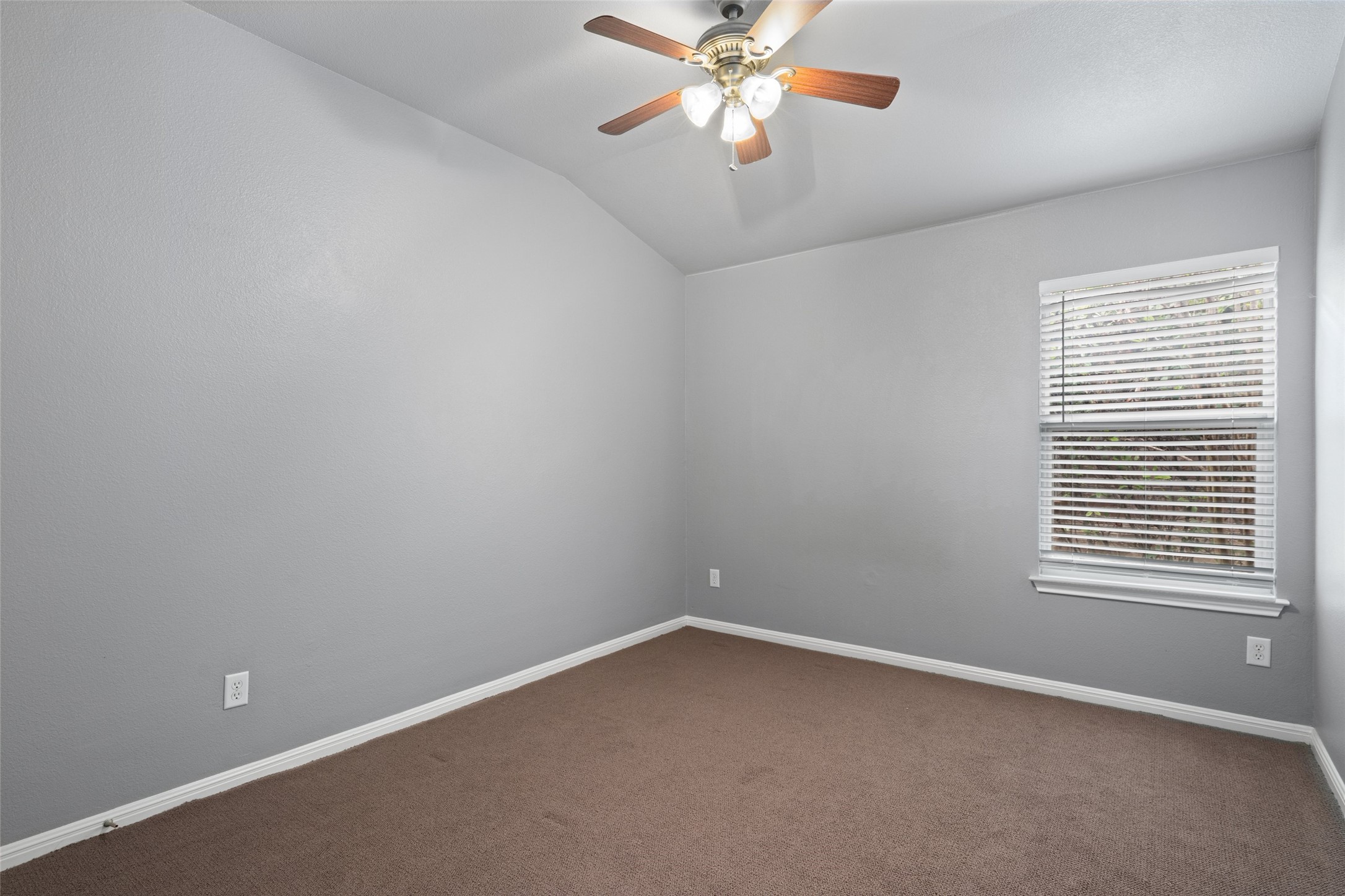 7013 Cromarty Lane Austin, TX 78754 - Photo 27 of 37 The room features a vaulted ceiling with a ceiling fan, a window with blinds, and carpeting