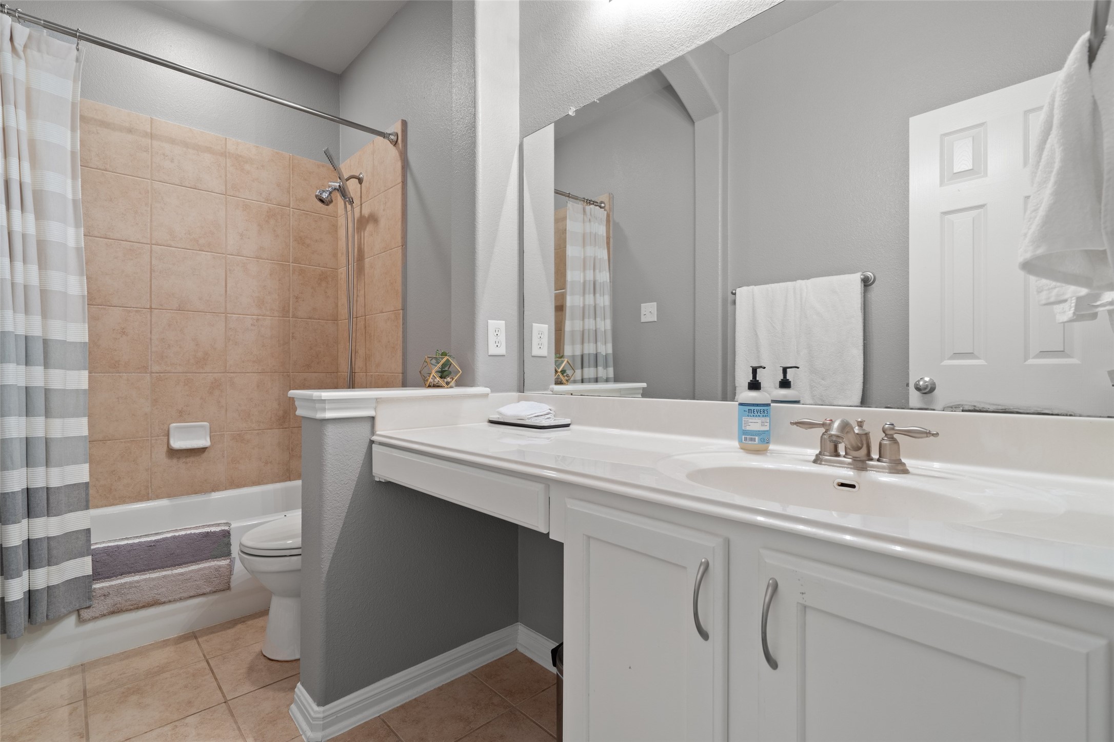7013 Cromarty Lane Austin, TX 78754 - Photo 29 of 37 This bathroom features a vanity with a sink, a mirror, and a bathtub with tiled walls