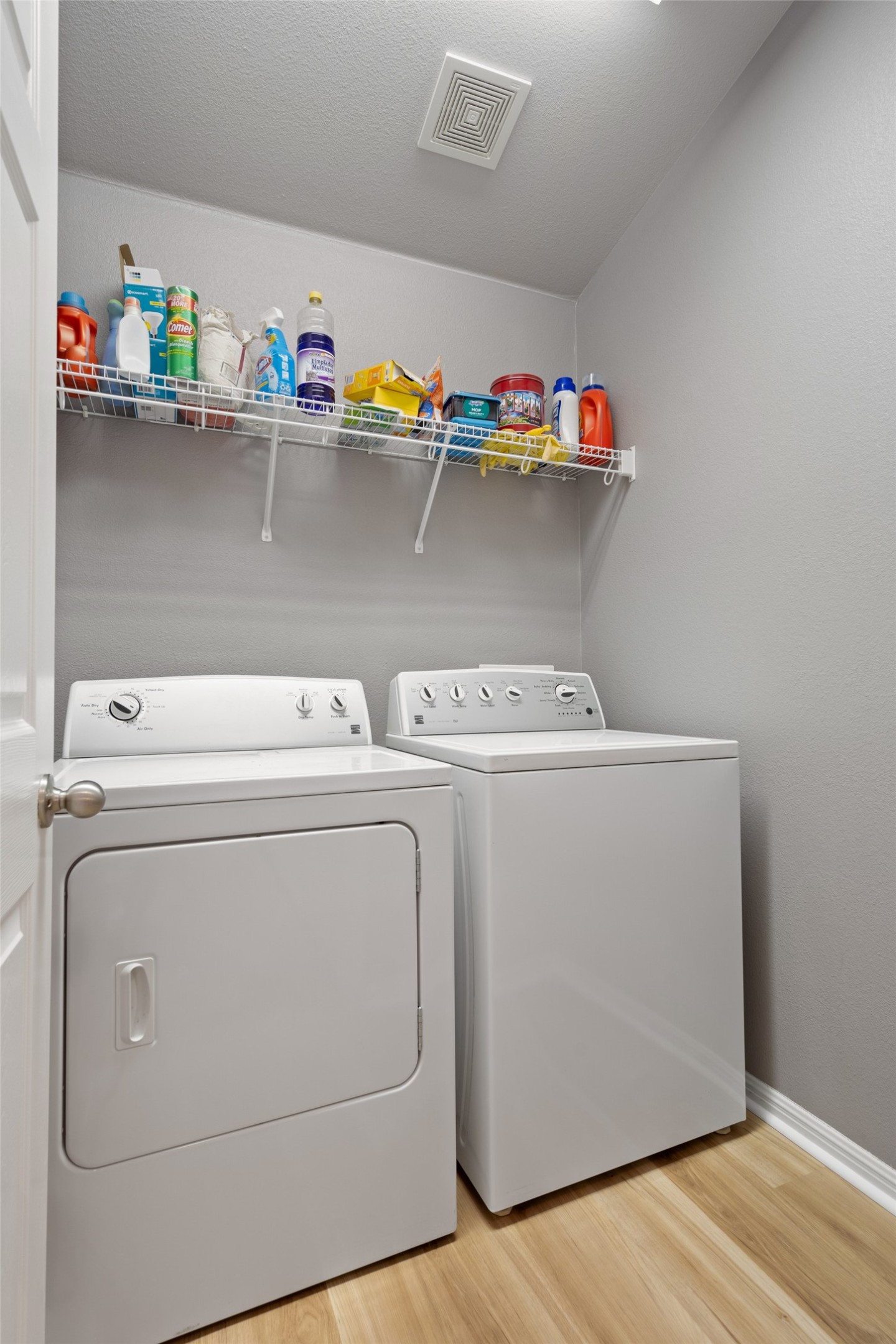 7013 Cromarty Lane Austin, TX 78754 - Photo 31 of 37 The utility area features a washing machine, a dryer, and a wall-mounted wire shelf for storage