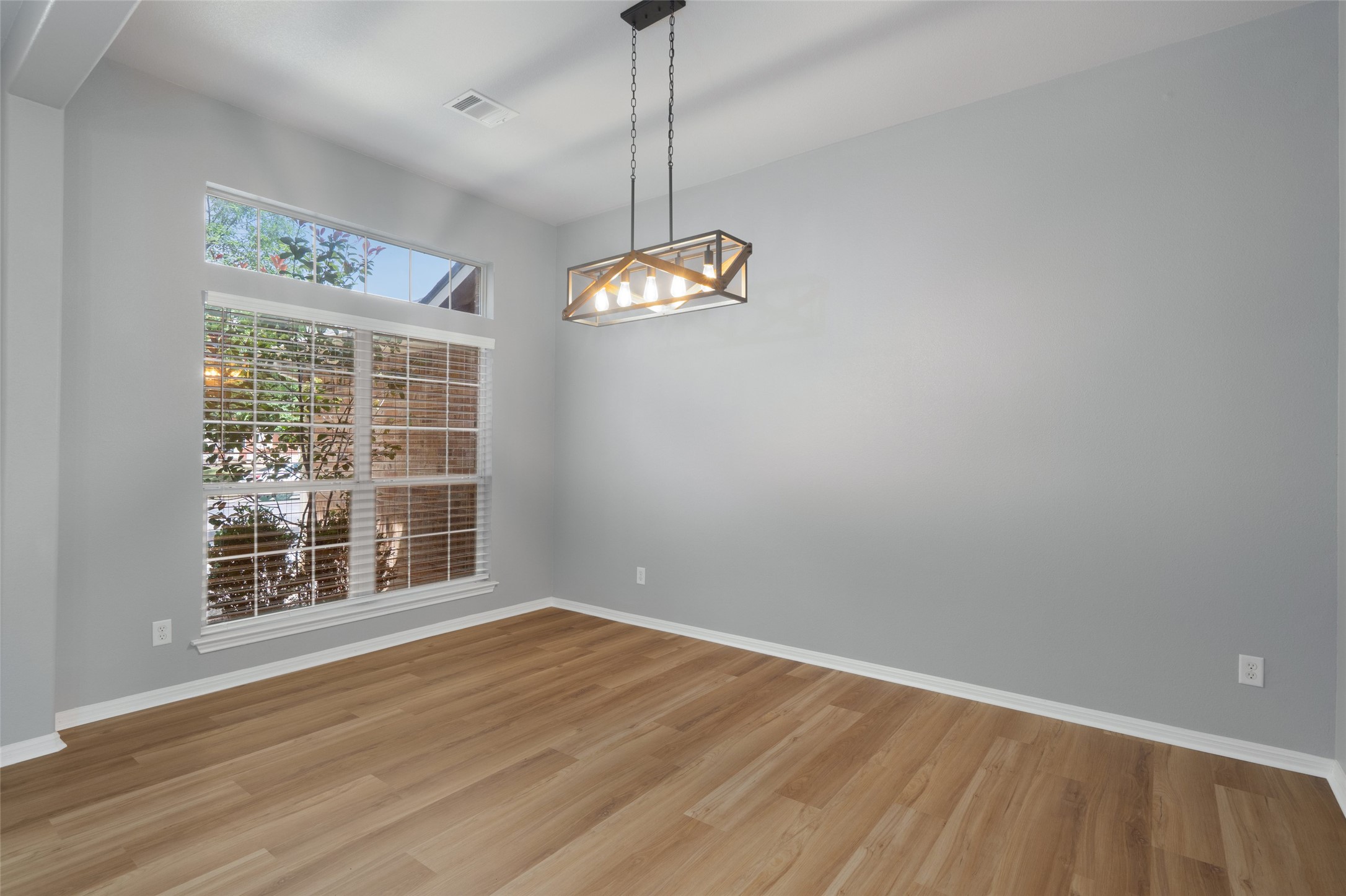 7013 Cromarty Lane Austin, TX 78754 - Photo 6 of 37 Living space featuring light-toned flooring, a large window with blinds, and a modern light fixture